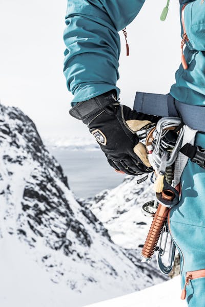 A person wearing mountaineering gloves