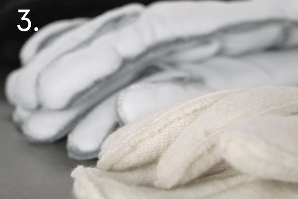 steg 3 sport Flera löstagbara foder placerade på en grå bänk i ett handskmakeri