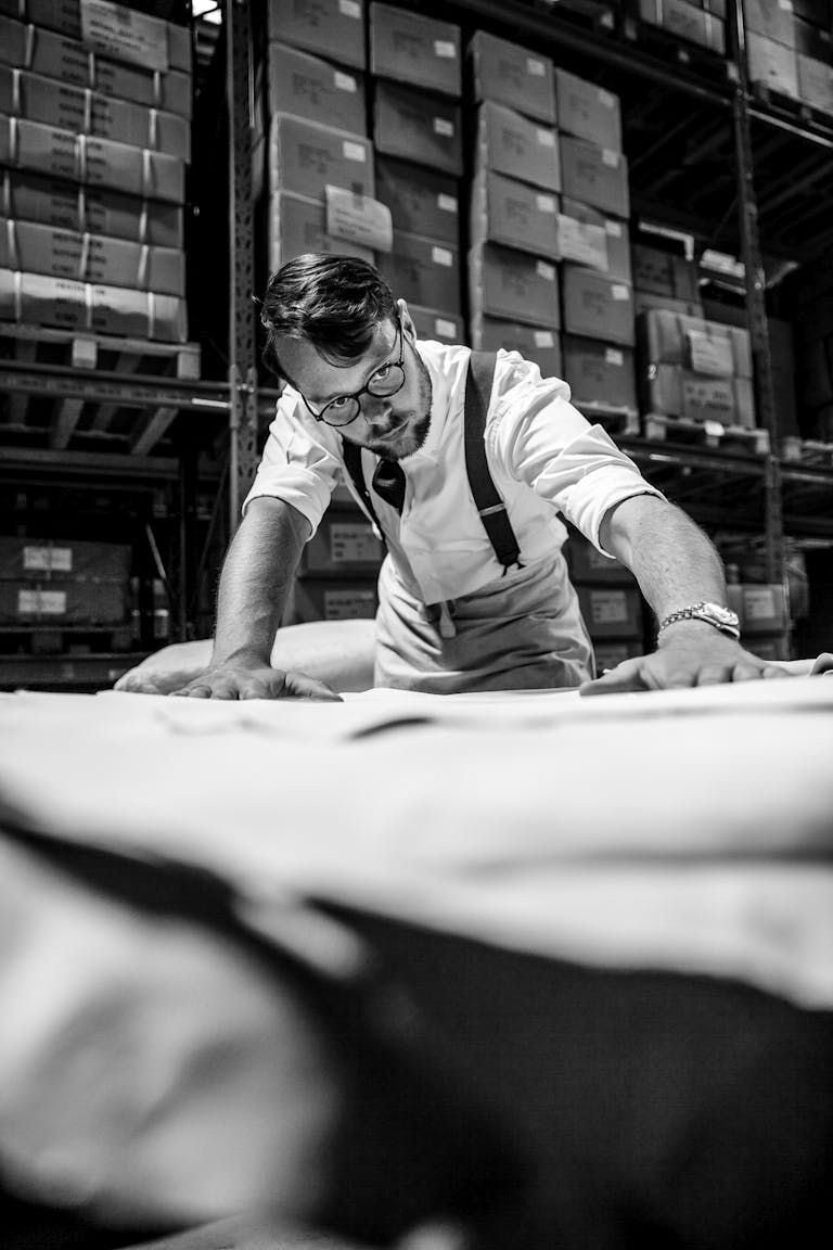 _MG_9665_1 En handskmakare kvalitets kontrollerar skinnet till handskar, med fokus på detaljerna i skinnet