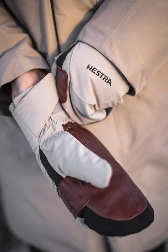 Eine Person in Winterkleidung, die den rechten Handschuh zurechtrückt