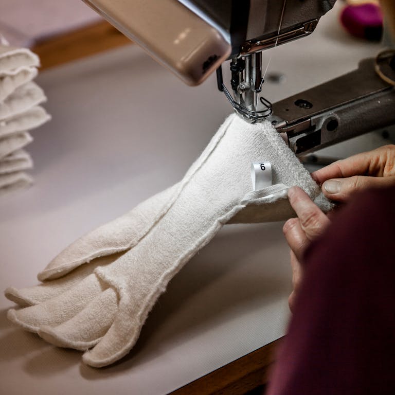 _MG_4519 A seamstress is sewing a white liner with the help of a sewing machine